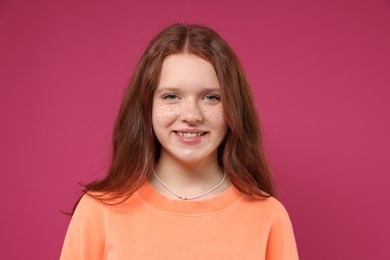 Photo of Beautiful teenage girl with freckles on pink background