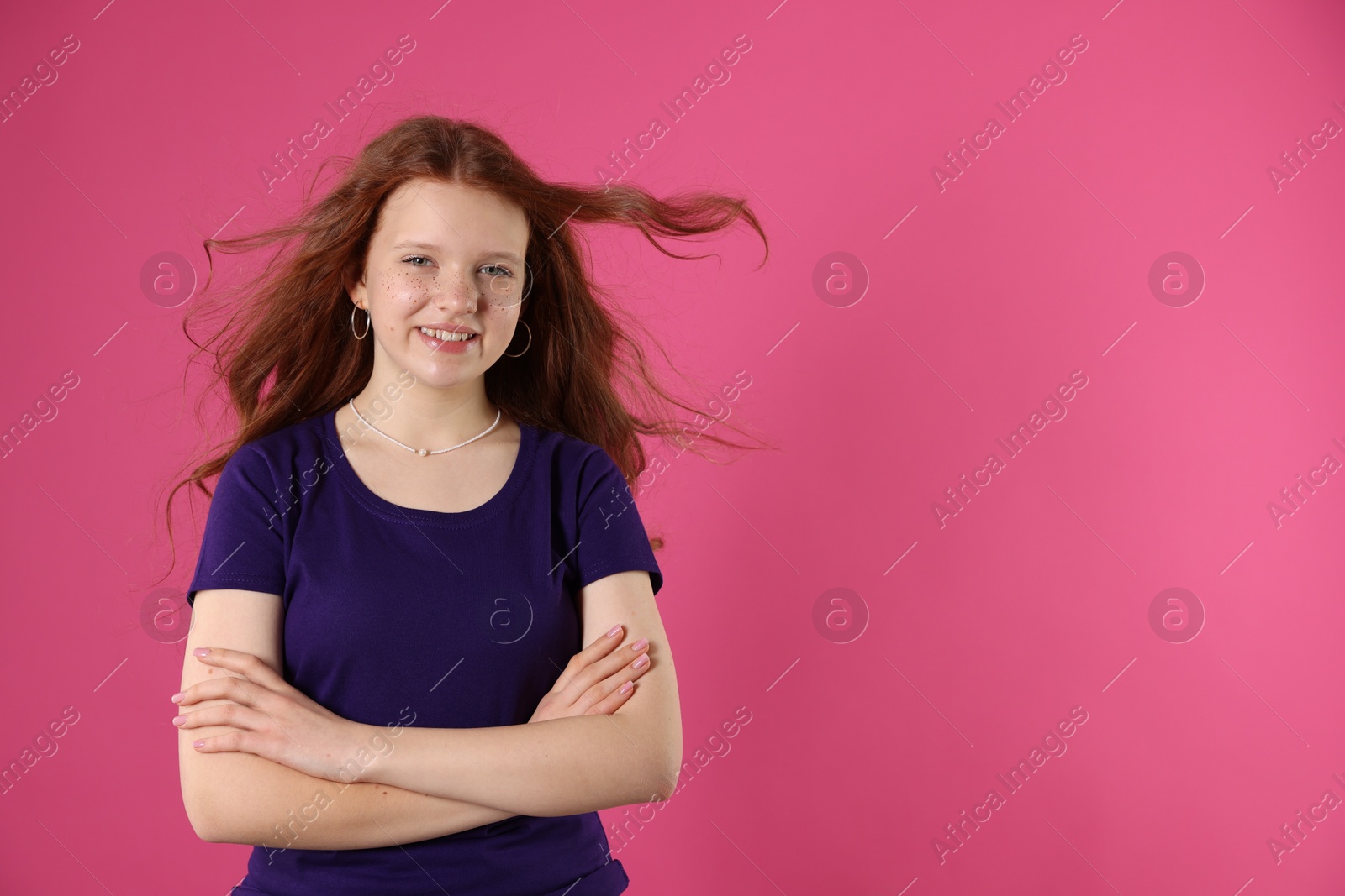 Photo of Beautiful teenage girl with freckles on pink background, space for text