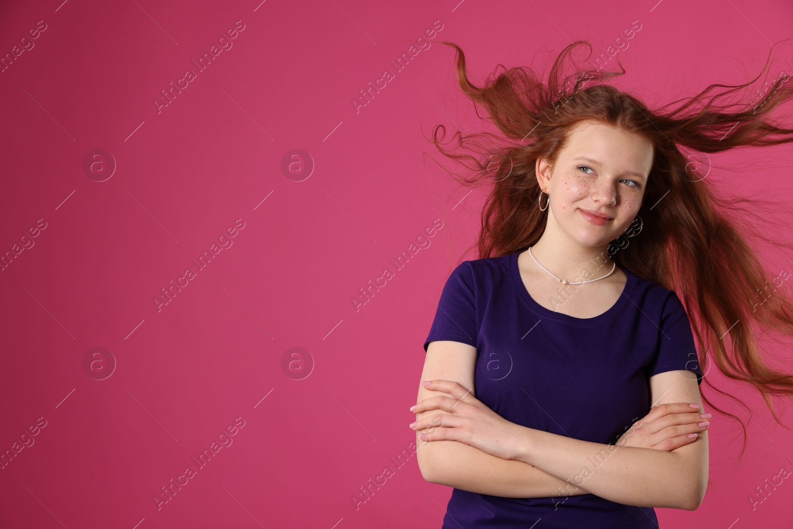 Photo of Beautiful teenage girl with freckles on pink background, space for text