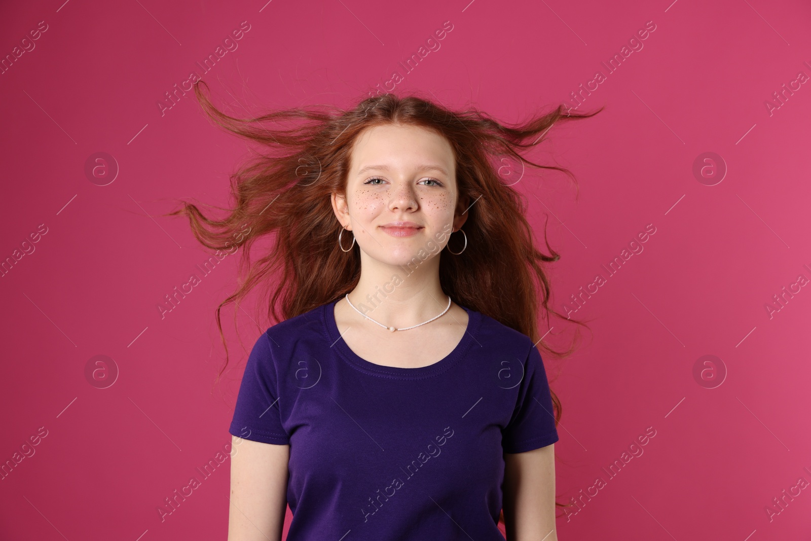 Photo of Beautiful teenage girl with freckles on pink background