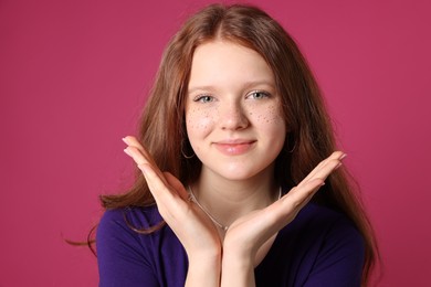 Photo of Beautiful teenage girl with freckles on pink background