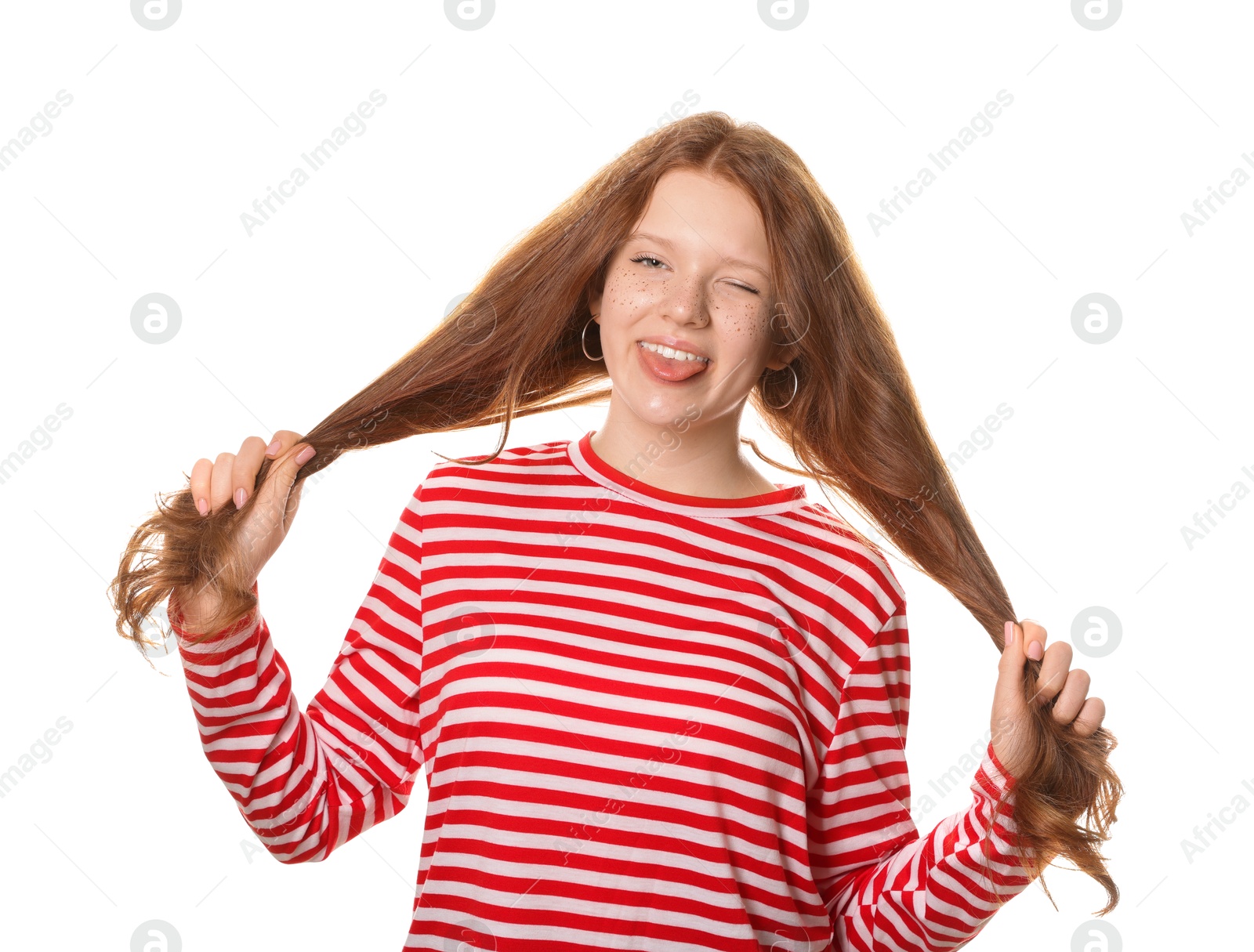 Photo of Beautiful teenage girl with freckles winking and showing her tongue on white background