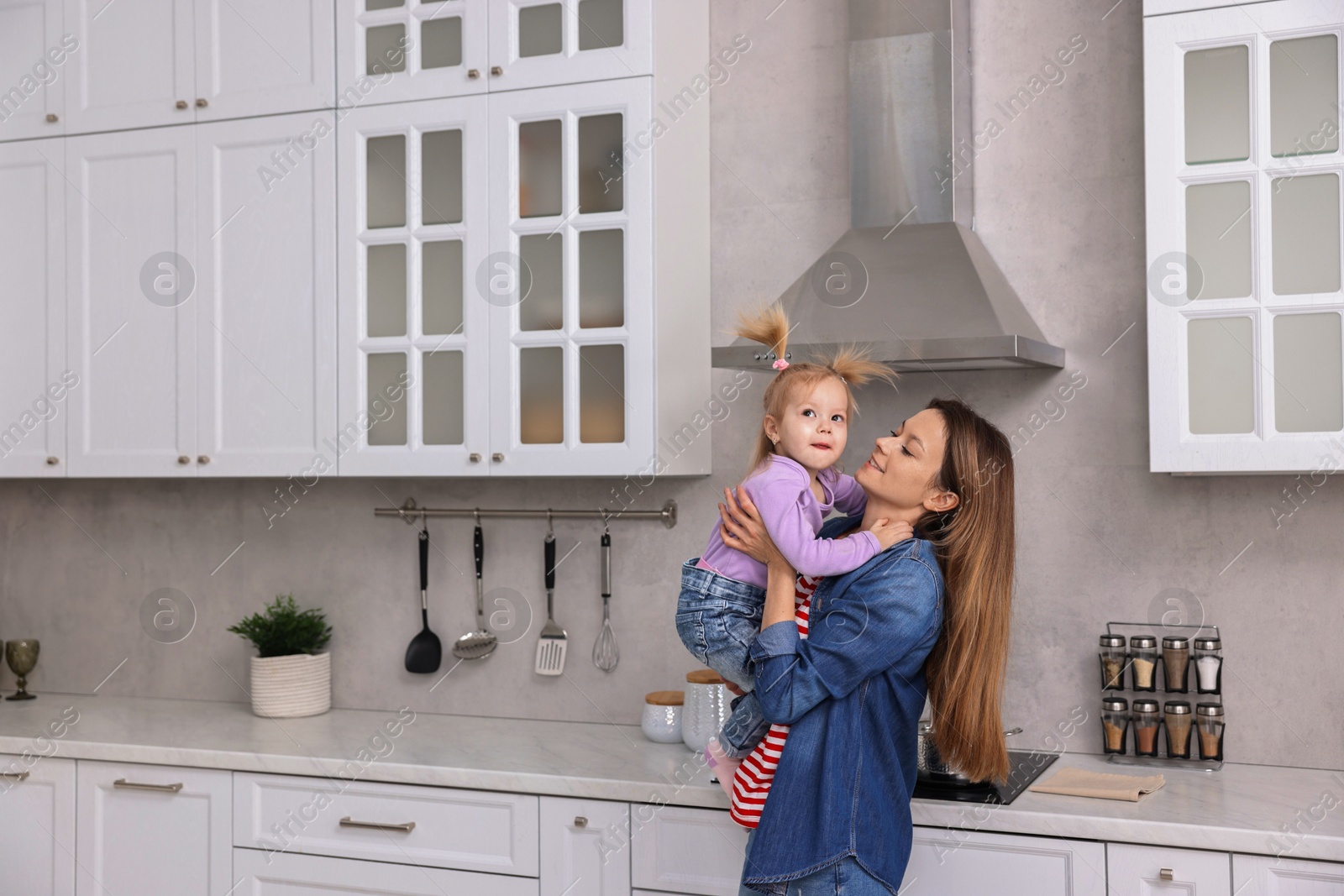 Photo of Happy housewife with her little daughter in kitchen