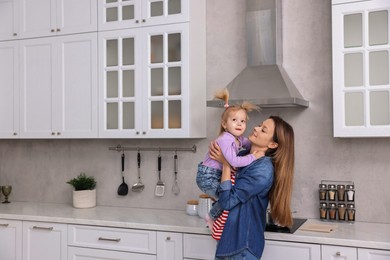 Photo of Happy housewife with her little daughter in kitchen