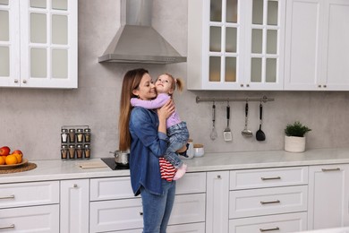 Photo of Happy housewife with her little daughter in kitchen