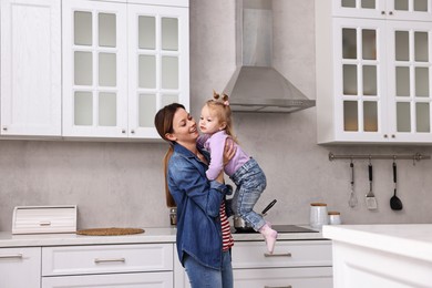 Photo of Happy housewife with her little daughter in kitchen