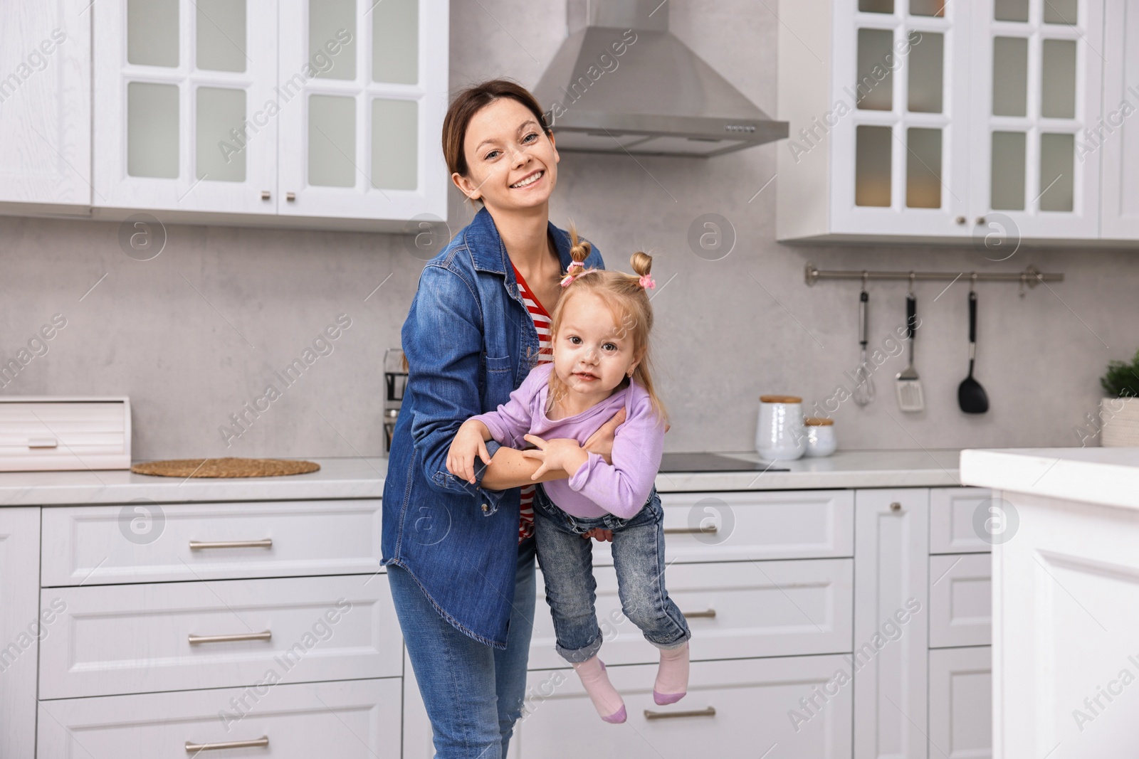 Photo of Happy housewife with her little daughter in kitchen