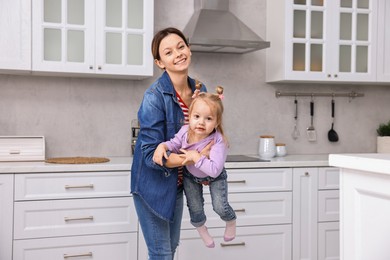 Photo of Happy housewife with her little daughter in kitchen