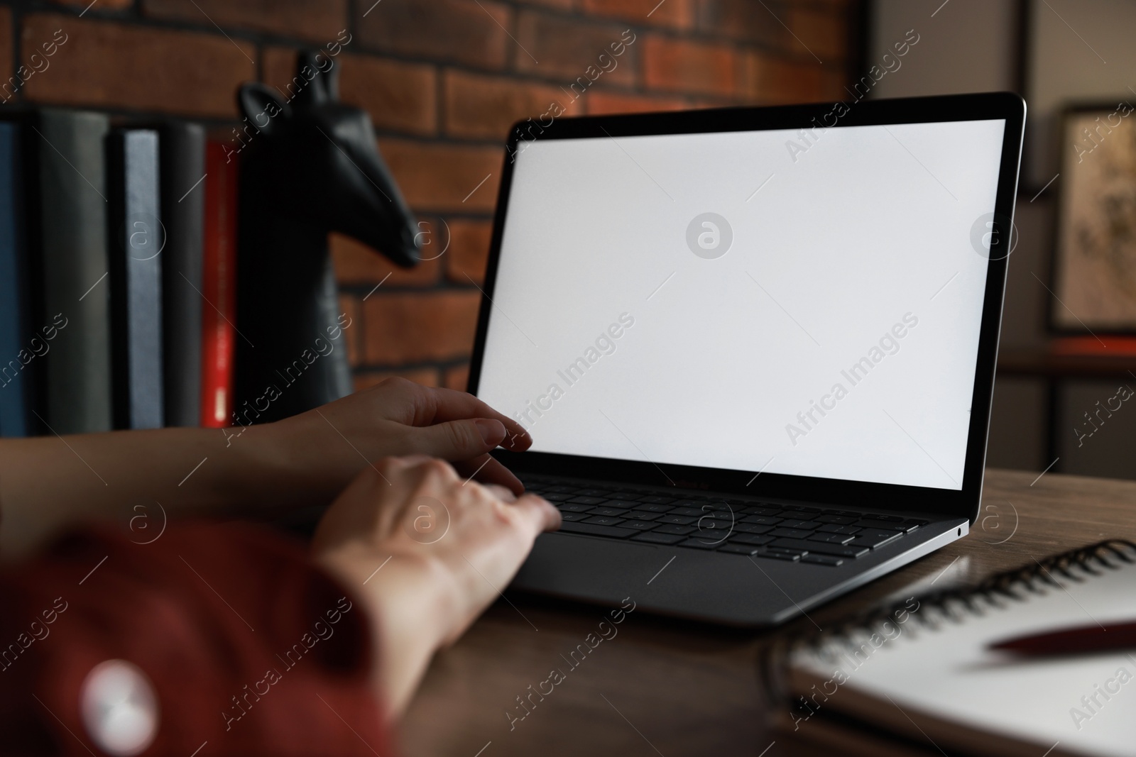 Photo of Woman working with laptop at table in office, closeup