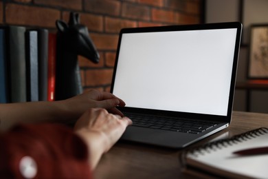 Photo of Woman working with laptop at table in office, closeup