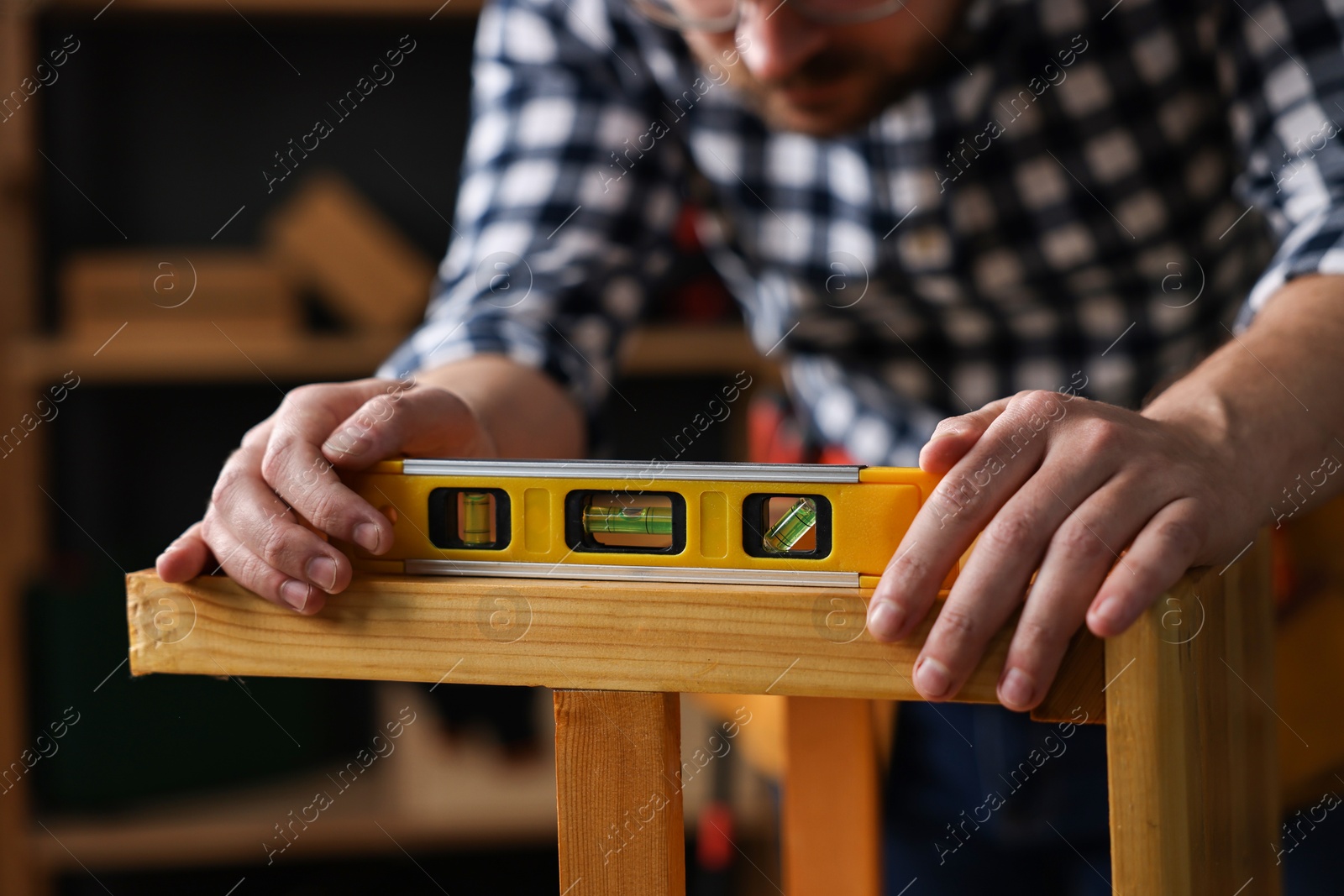 Photo of Repairman checking stool level in workshop, closeup