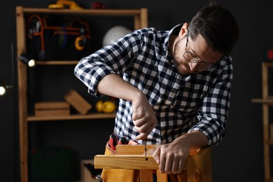 Photo of Professional carpenter repairing wooden stool in workshop