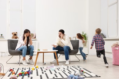 Photo of Hyperactive children playing and their overwhelmed parents at home