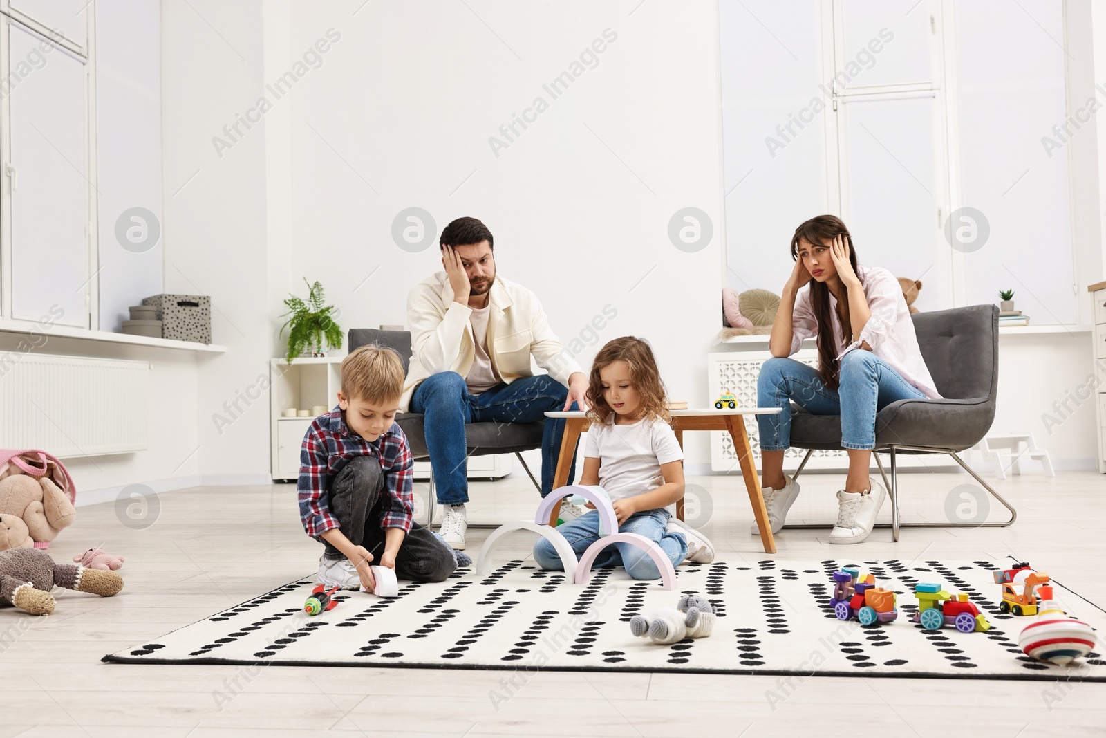 Photo of Hyperactive children playing and their overwhelmed parents at home