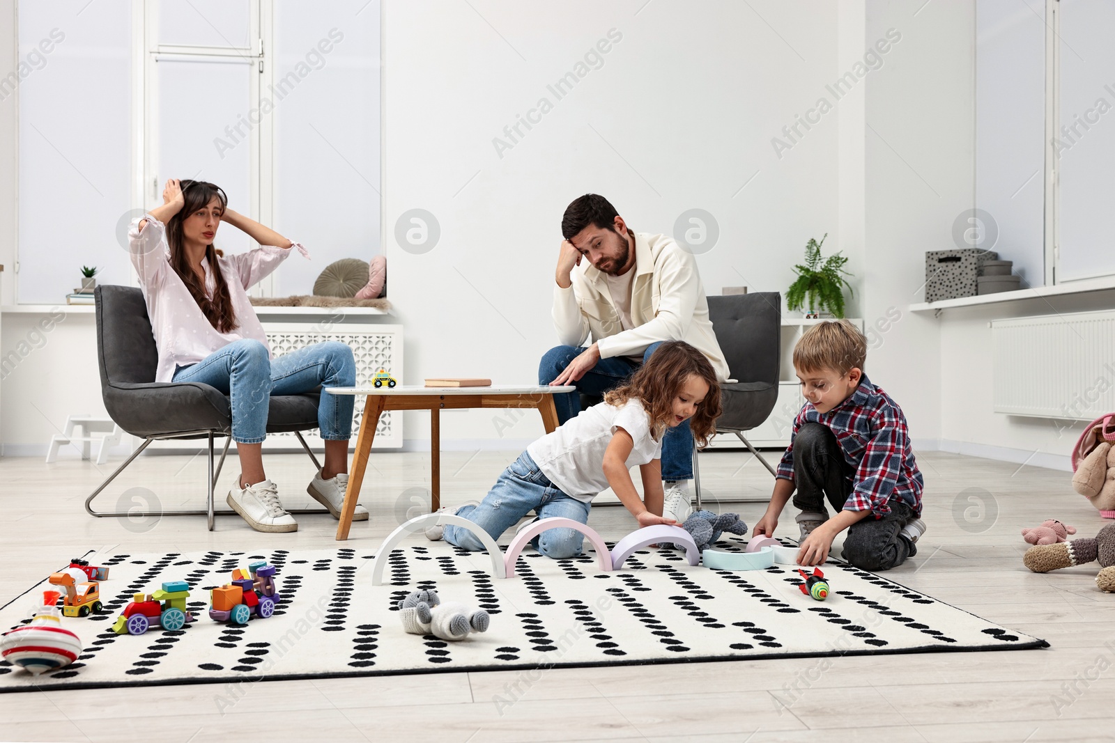 Photo of Hyperactive children playing and their overwhelmed parents at home