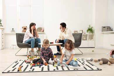 Photo of Hyperactive children playing and their overwhelmed parents at home