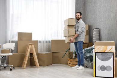 Photo of Moving day. Man with cardboard boxes in his new home