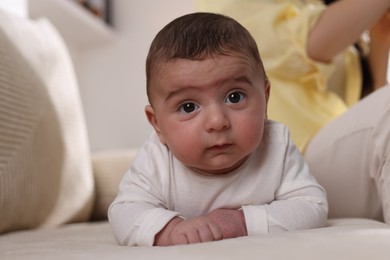 Photo of Mother with her little baby on sofa at home, closeup