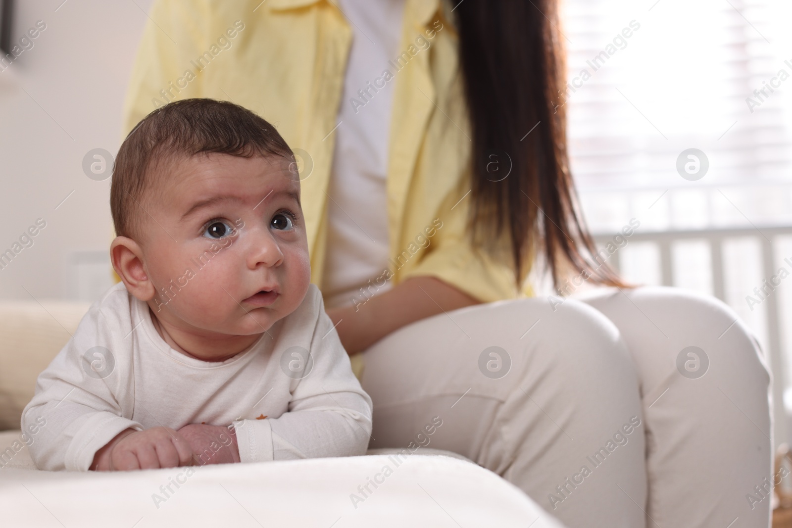 Photo of Mother with her little baby on sofa at home, closeup