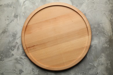 Photo of Wooden board on grey textured table, top view