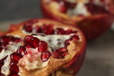 Photo of Fresh juicy pomegranates on grey table, closeup