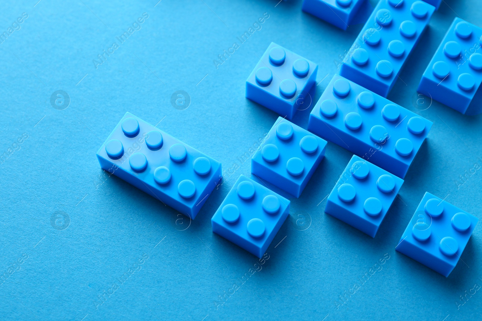 Photo of Constructor toy. Many building blocks on light blue background, above view