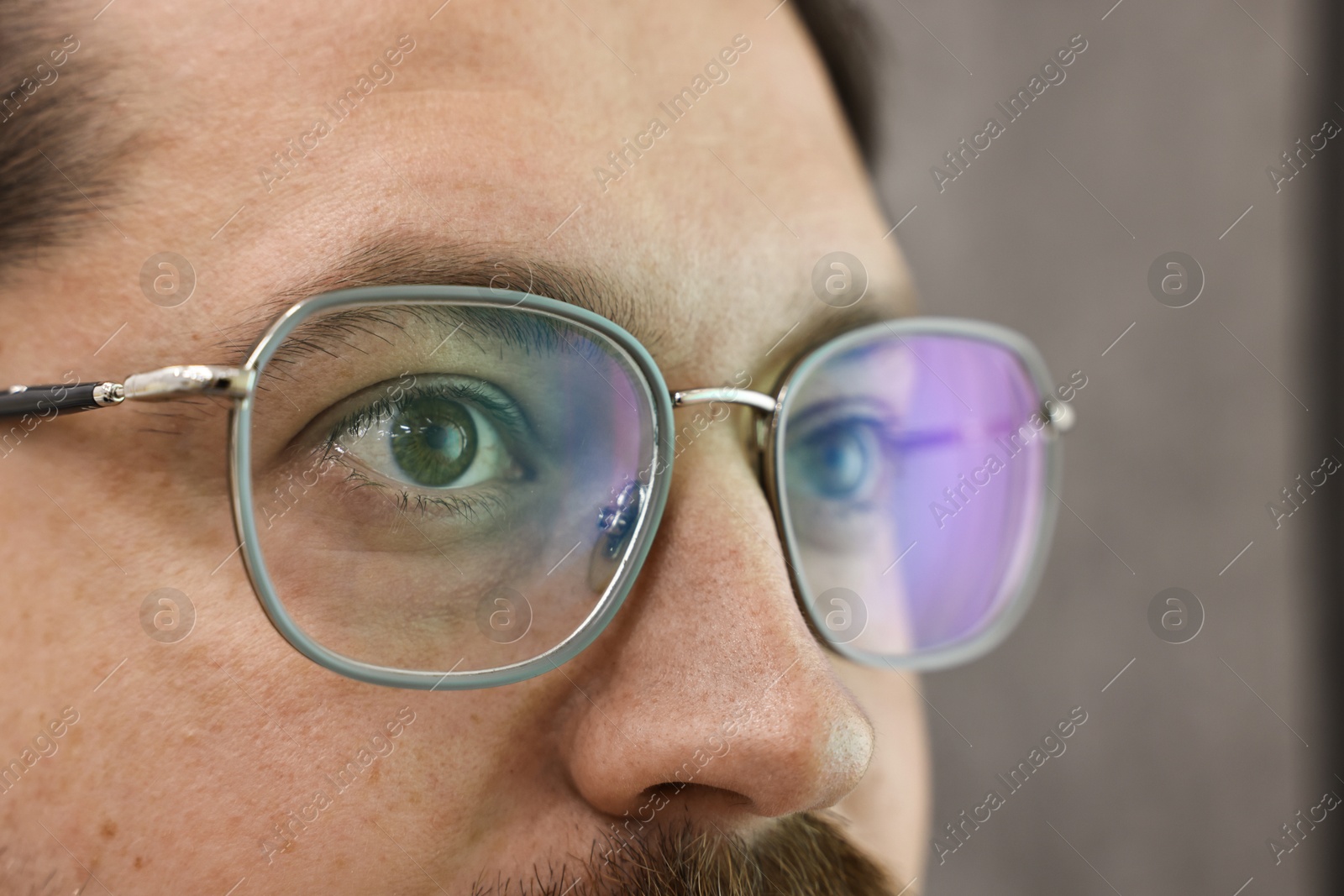 Photo of Man wearing stylish glasses on blurred background, closeup