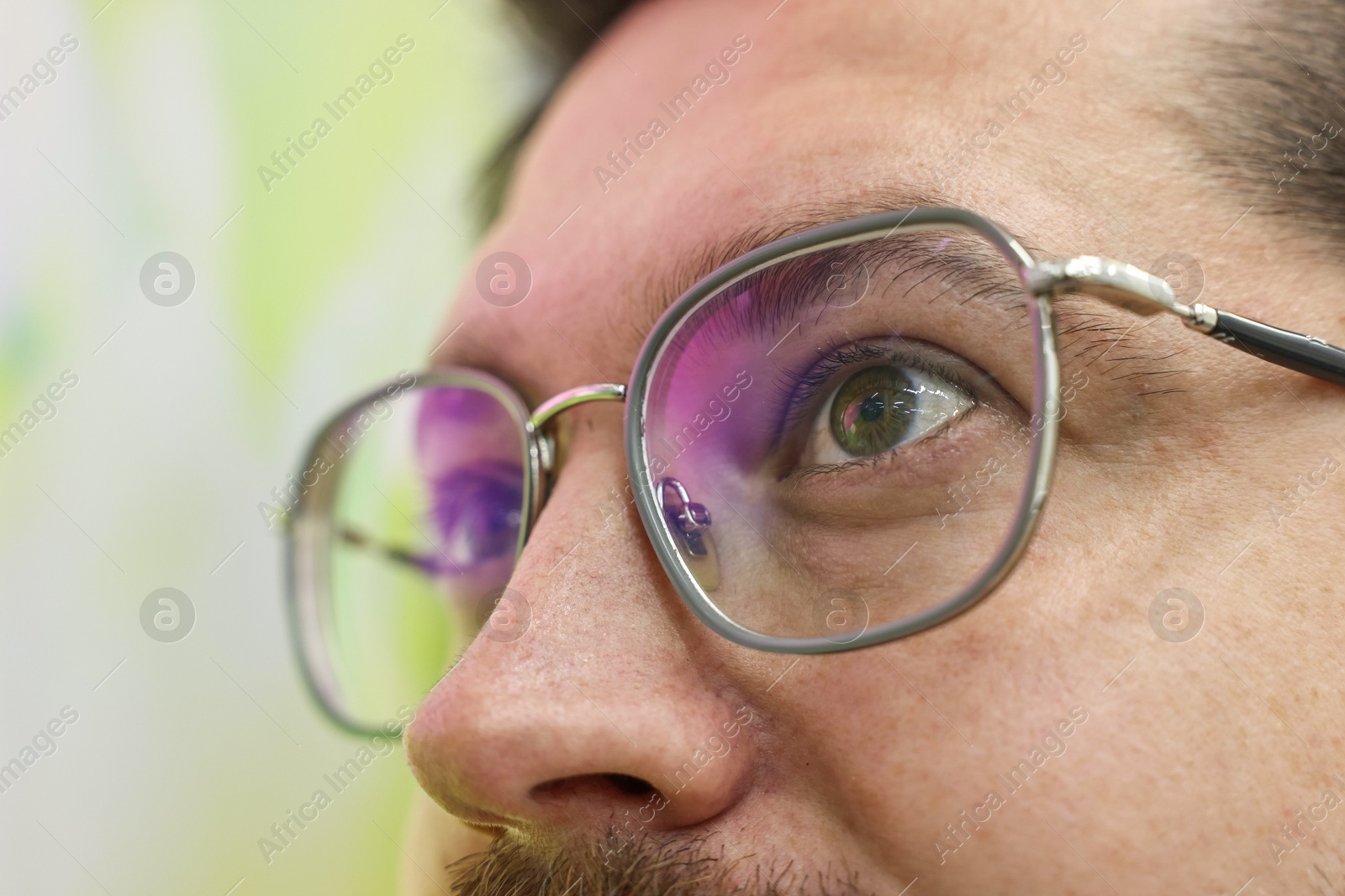 Photo of Man wearing stylish glasses on blurred background, closeup