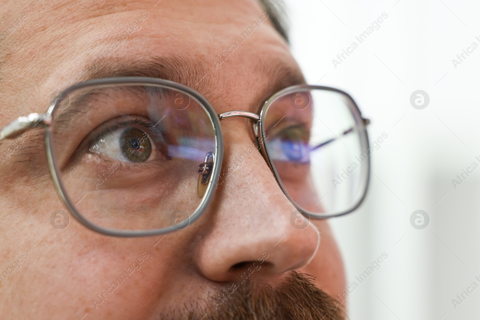 Photo of Man wearing stylish glasses on blurred background, closeup