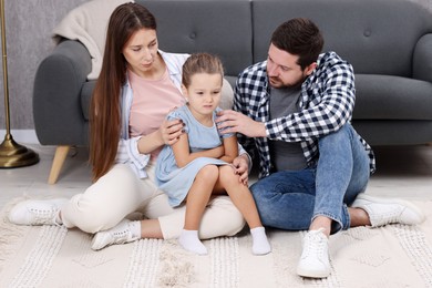 Photo of Resentful little girl and her parents at home. Family dispute