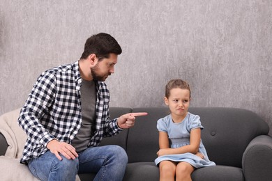 Photo of Resentful little girl and her father arguing at home