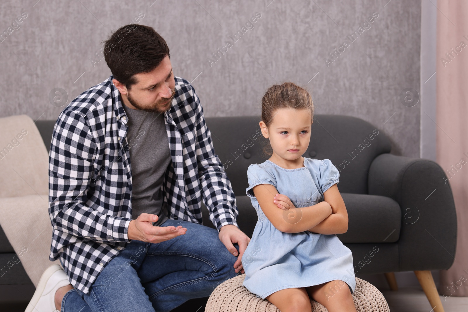 Photo of Resentful little girl and her father arguing at home