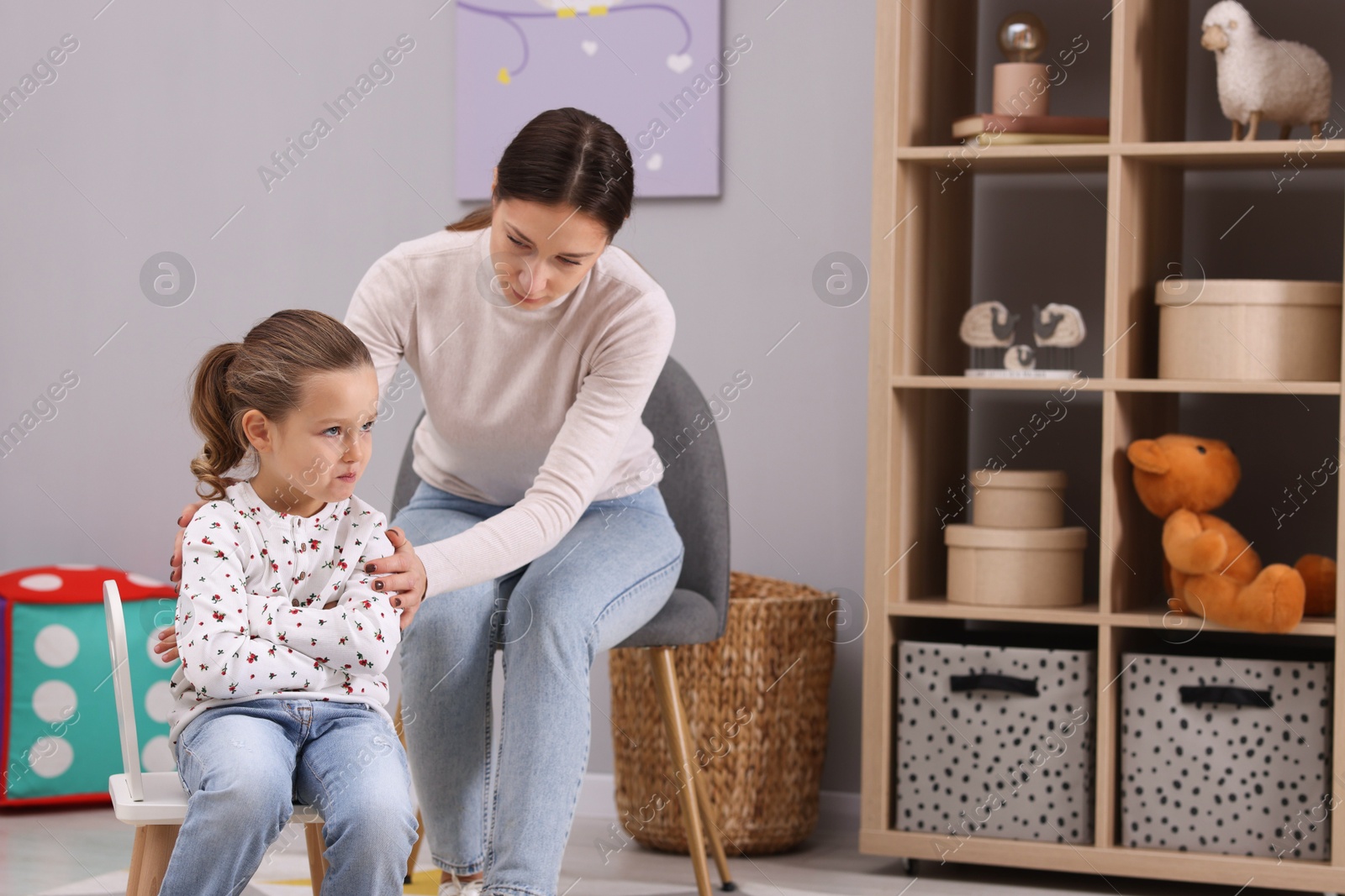 Photo of Resentful little girl and her mother at home, space for text. Family dispute