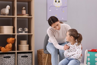 Photo of Resentful little girl and her mother at home, space for text. Family dispute