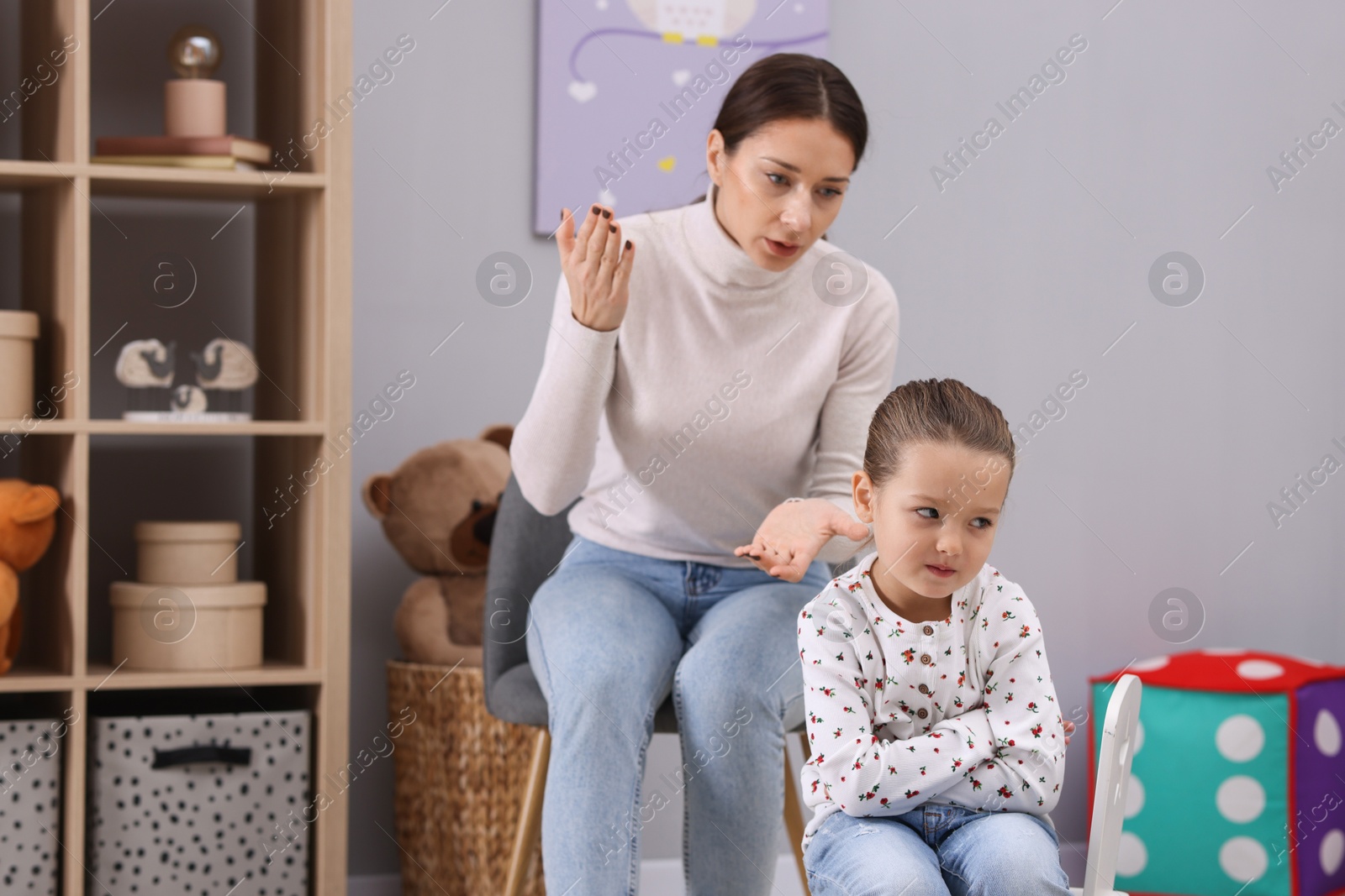 Photo of Resentful little girl and her mother arguing at home