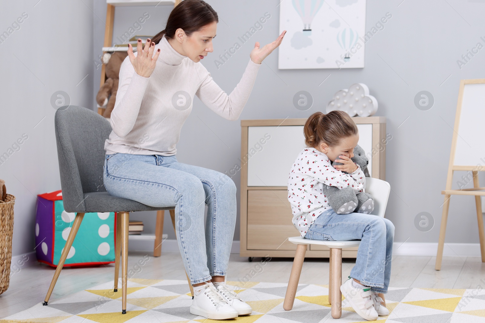 Photo of Resentful little girl and her mother arguing at home