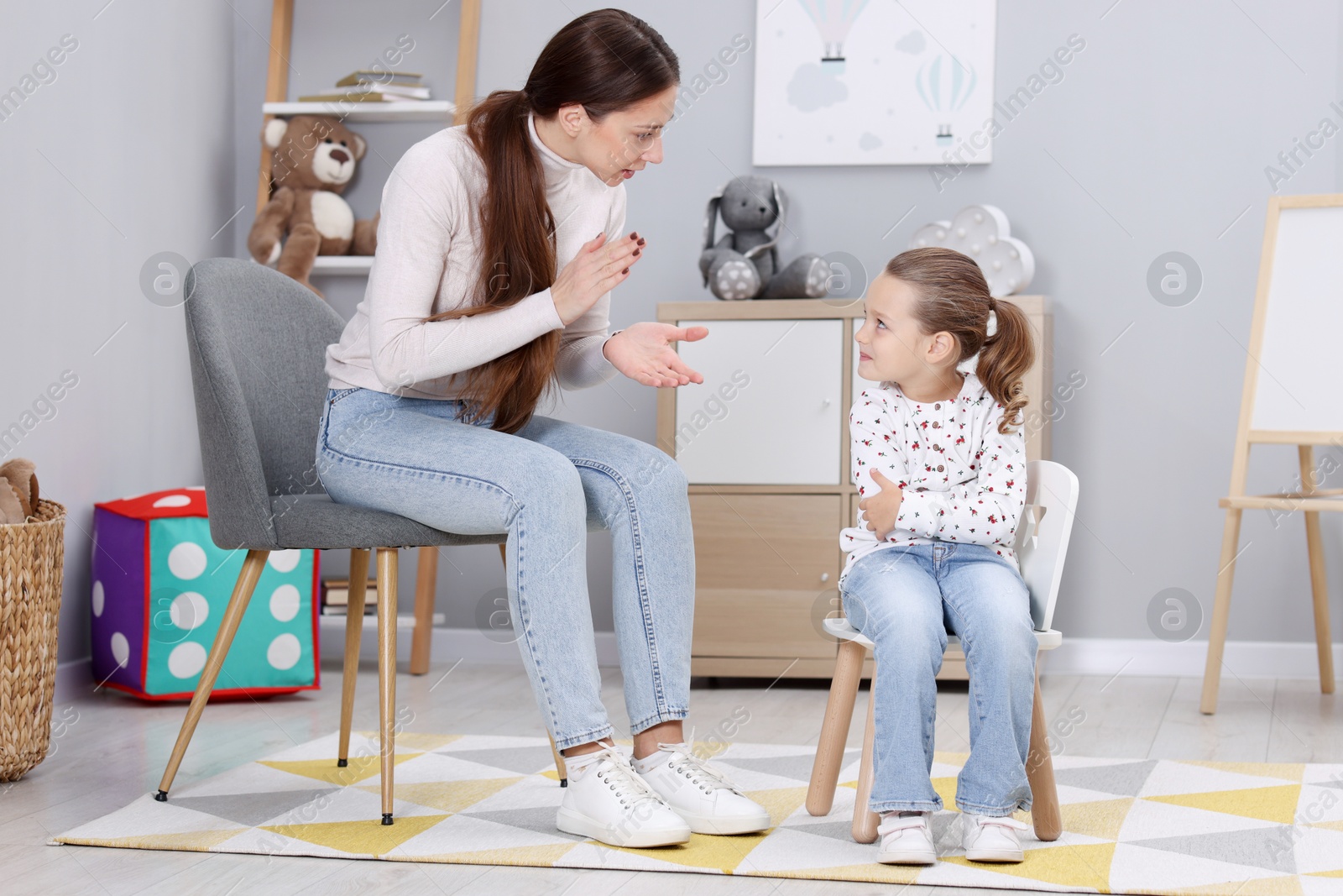 Photo of Resentful little girl and her mother arguing at home