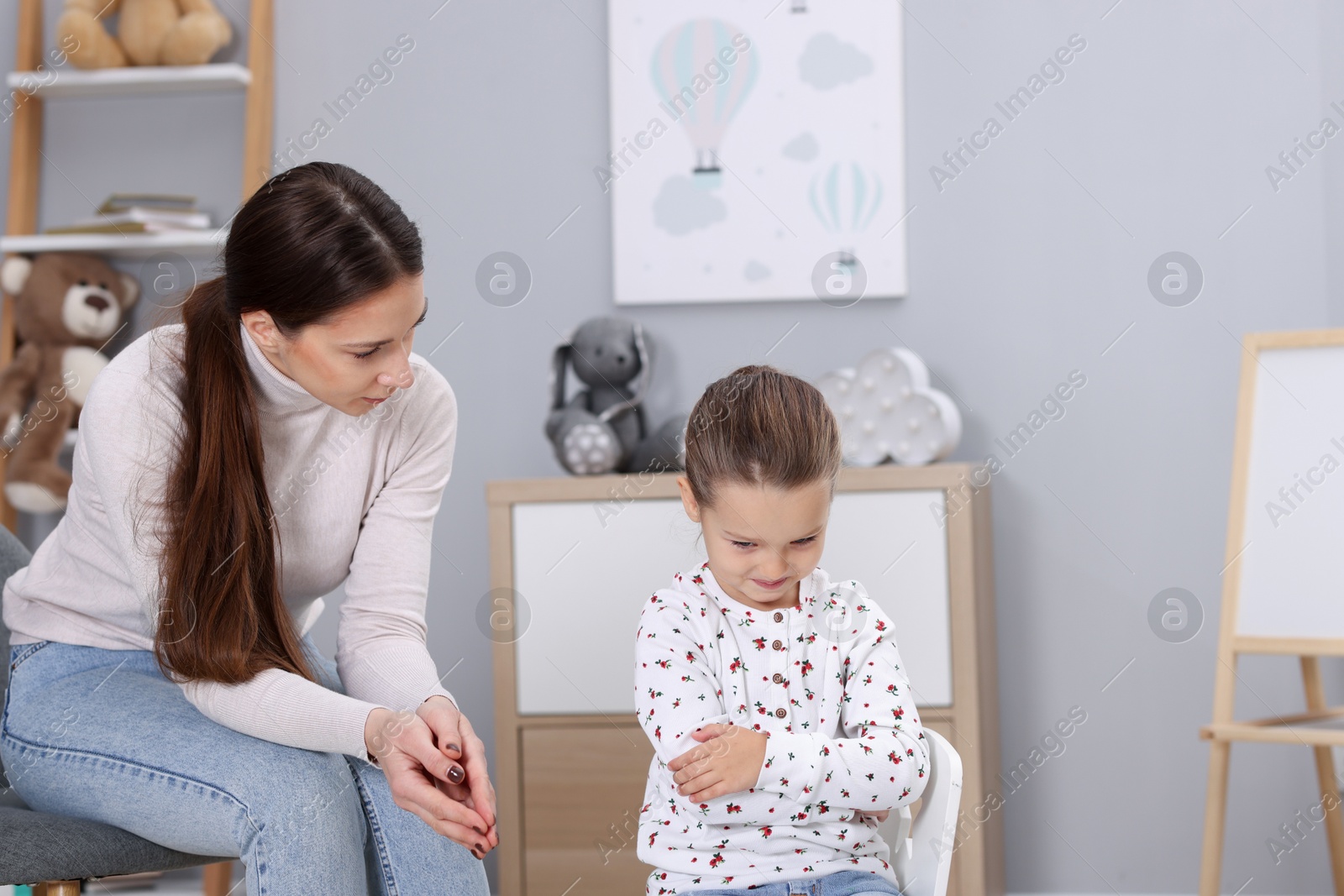 Photo of Resentful little girl and her mother at home