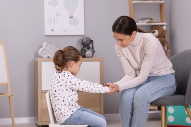 Photo of Resentful little girl and her mother at home