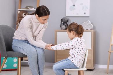 Photo of Resentful little girl and her mother at home