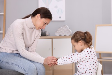 Photo of Resentful little girl and her mother at home