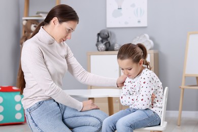 Photo of Resentful little girl and her mother at home