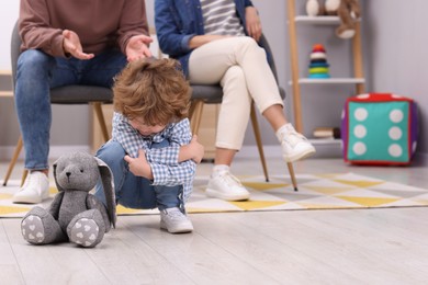 Photo of Resentful little boy and his parents at home, space for text. Family dispute