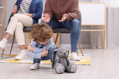 Photo of Resentful little boy and his parents at home, space for text. Family dispute