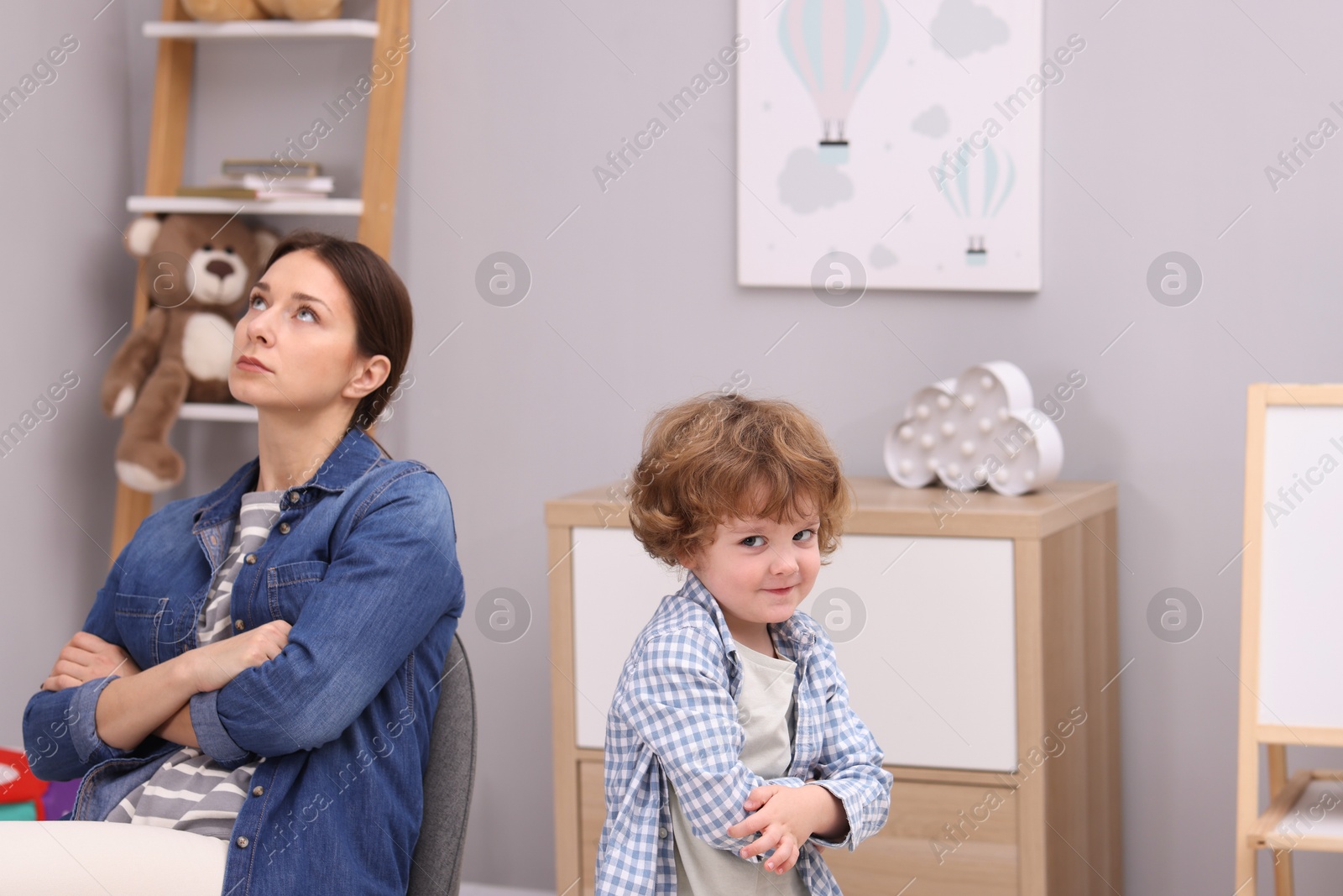 Photo of Resentful little boy and his mother arguing at home