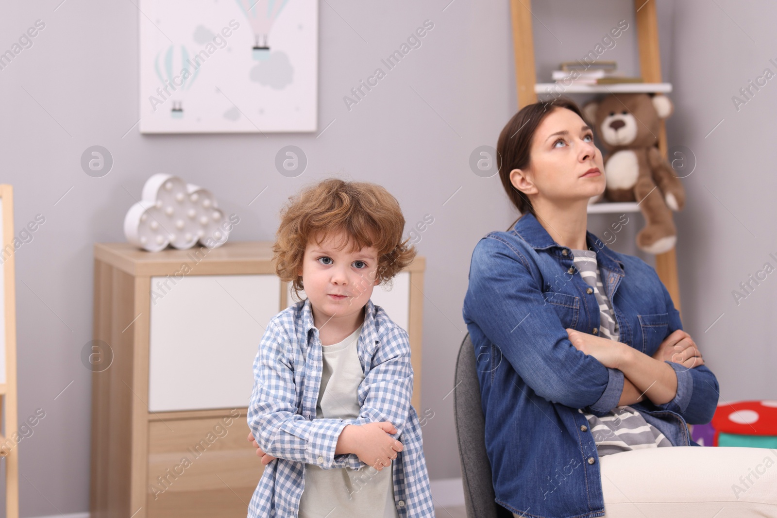 Photo of Resentful little boy and his mother arguing at home