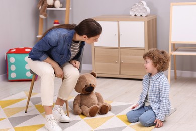 Photo of Resentful little boy and his mother arguing at home