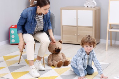 Photo of Resentful little boy and his mother arguing at home