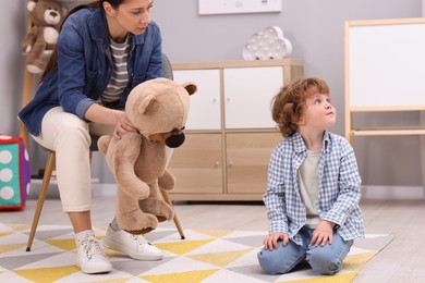 Photo of Resentful little boy and his mother arguing at home