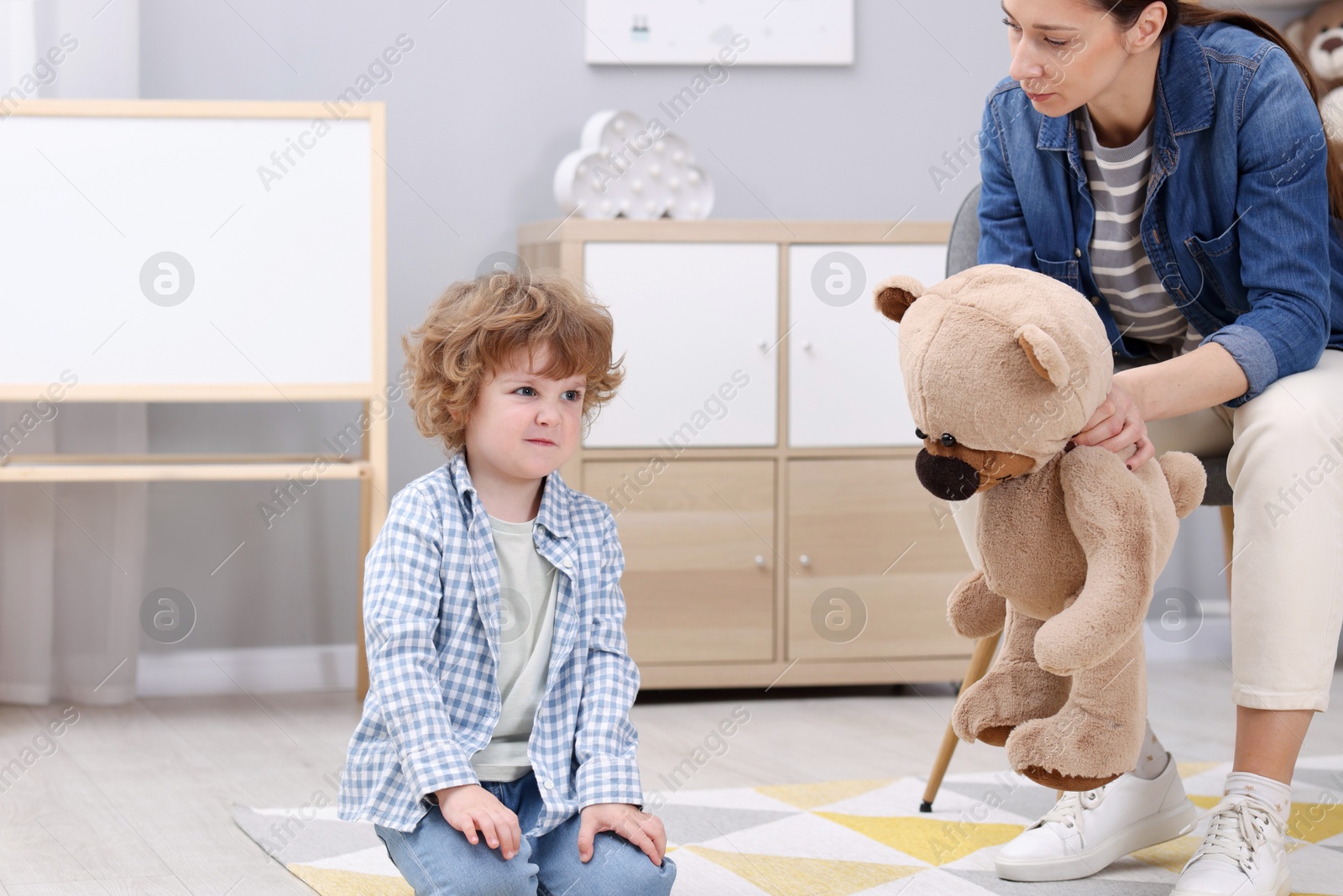 Photo of Resentful little boy and his mother arguing at home